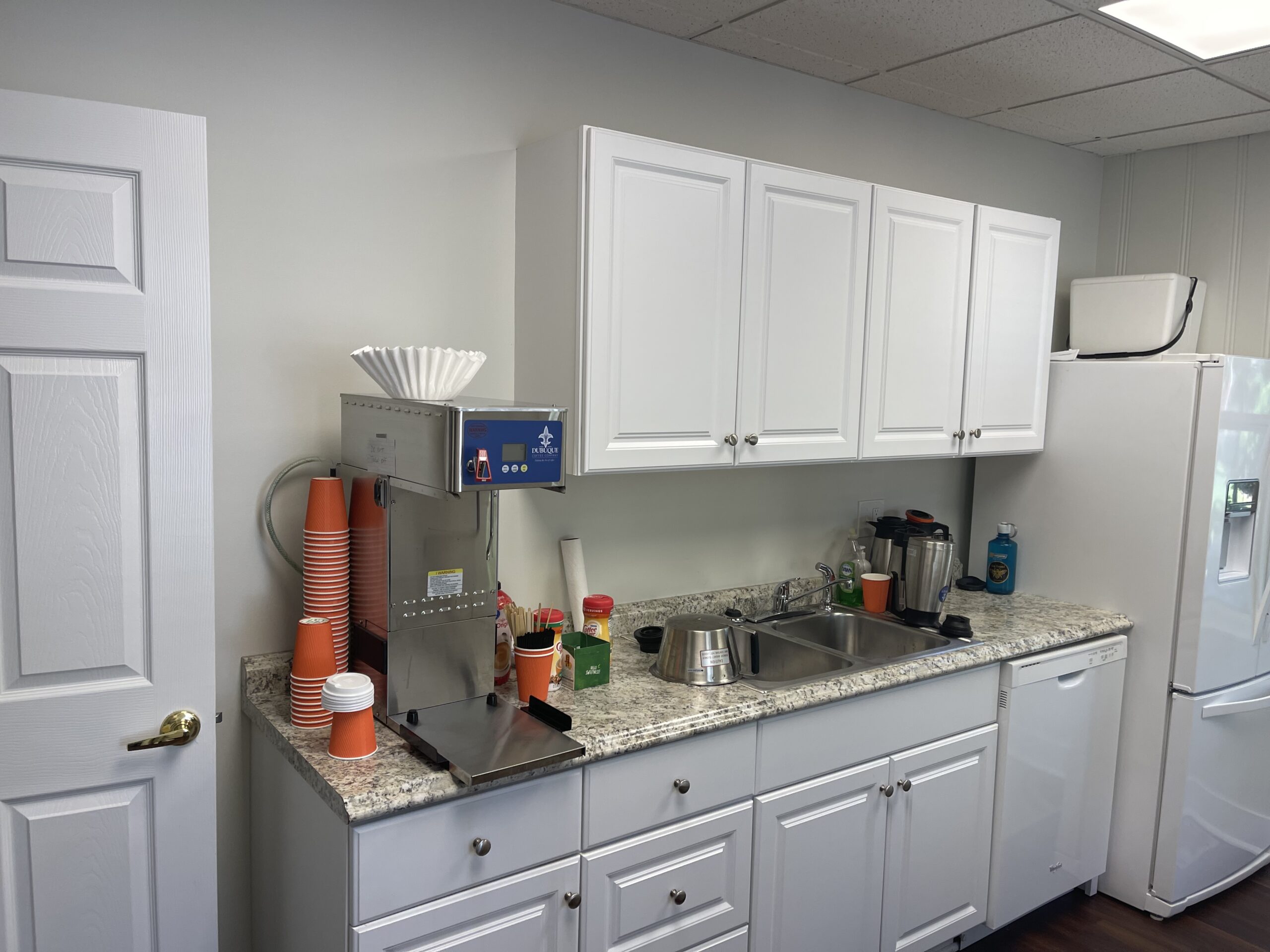 A kitchen with white cabinets and granite counter tops.