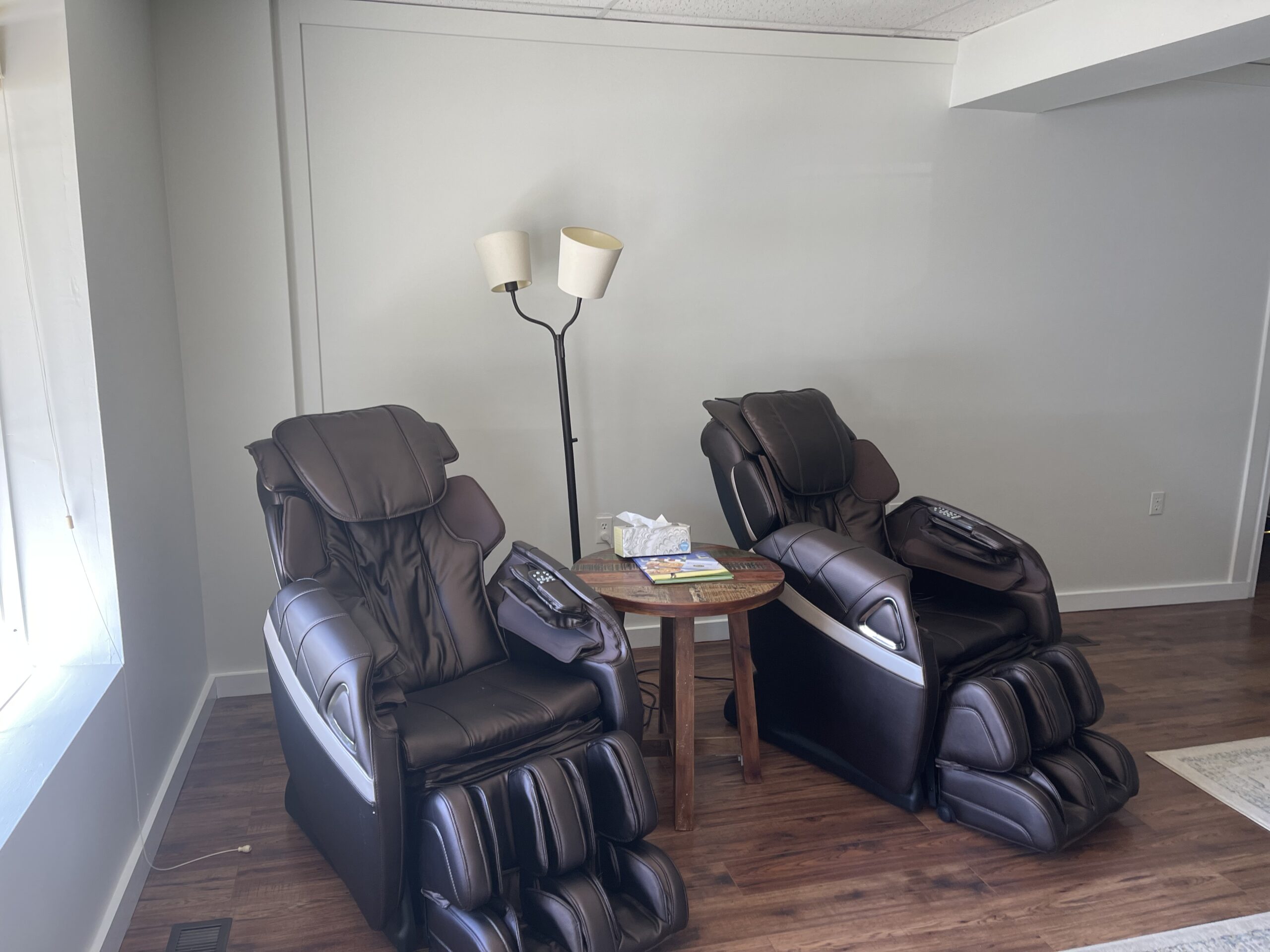 Two black leather recliner chairs in a room.